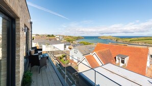 Un balcone con vista sul mare e sugli edifici circostanti.