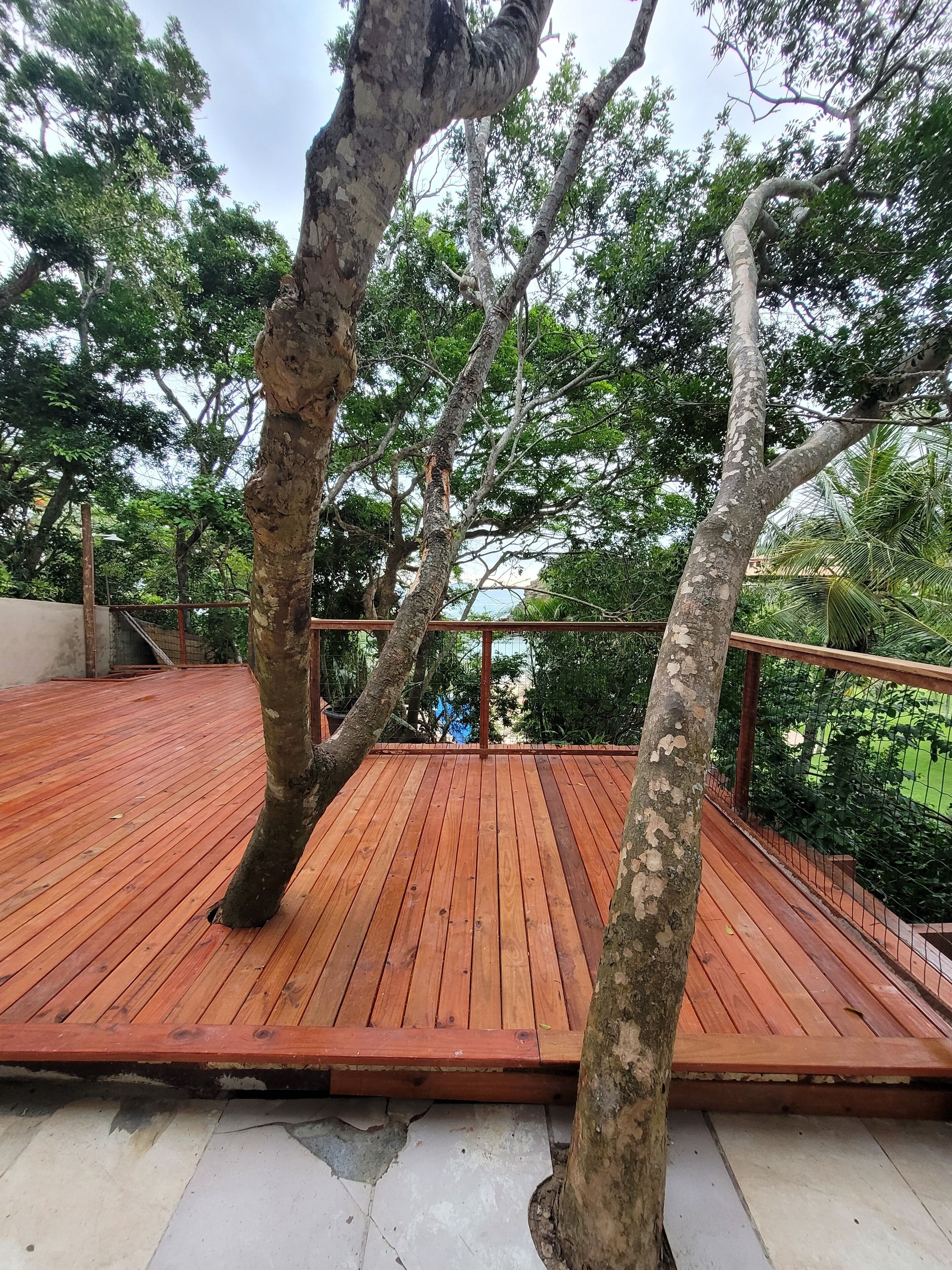 A wooden deck with trees in the background.