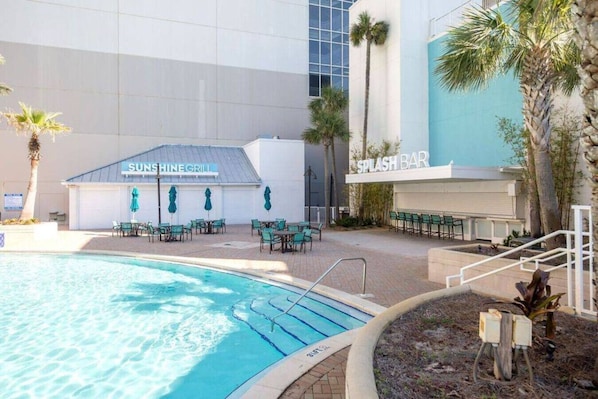 A pool area with a 'Sunshine Grill' and a 'Splash Bar'. - Beautiful Gulf View at Laketown Wharf 624 | No Elevators Needed, Beach Access, 5 Pools, Two-Story Gym, Rooftop PuttPutt (Panama City Beach)