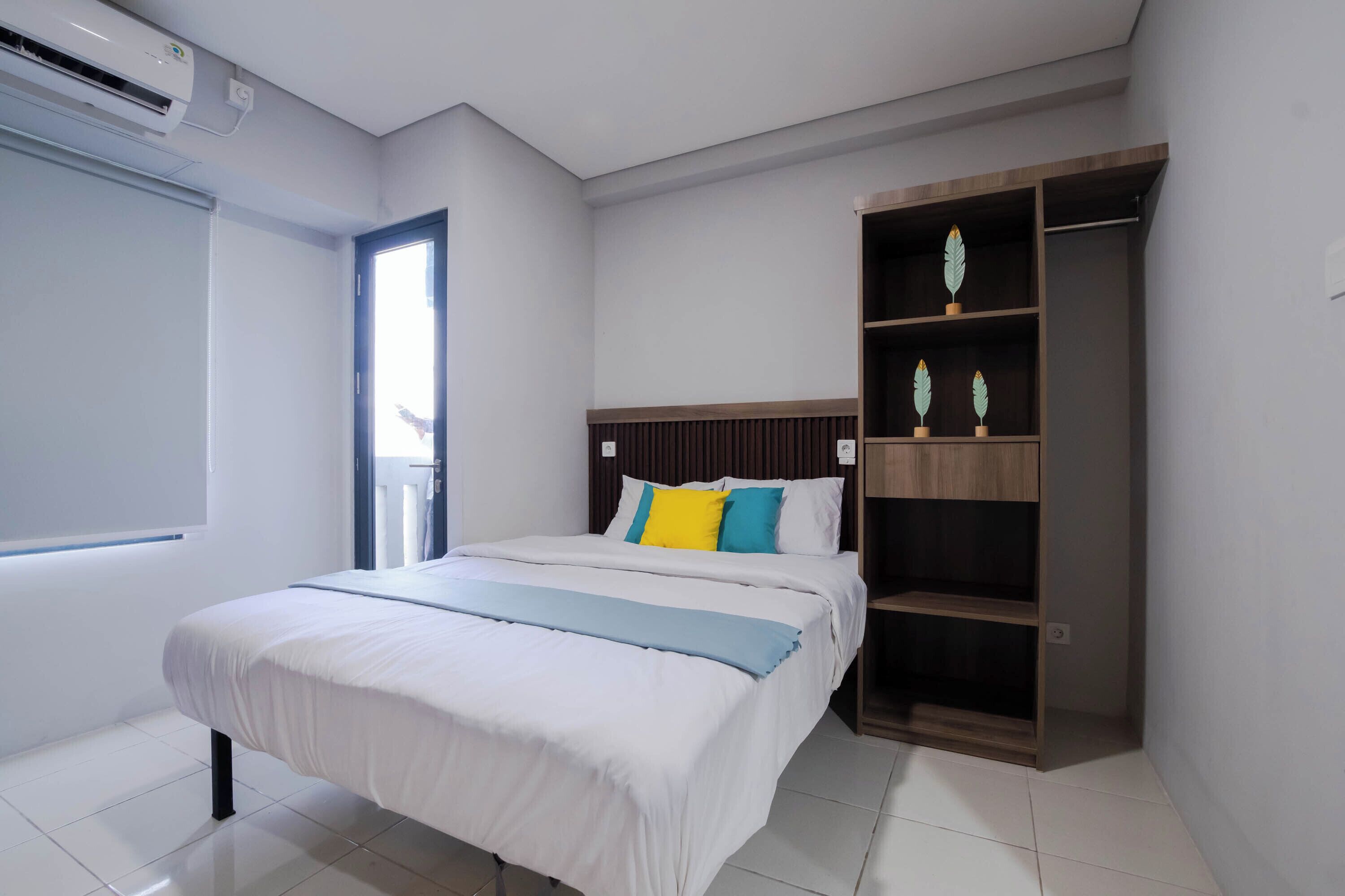 Un dormitorio con cama, armario y ventana.