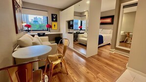 Une chambre d’hôtel moderne comprenant un coin repas, un canapé, une télévision et un lit.