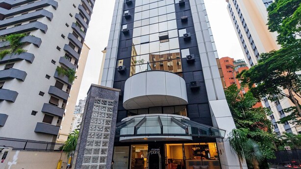 Un hôtel moderne doté d’une entrée en verre, de plusieurs étages et d’un atrium central.