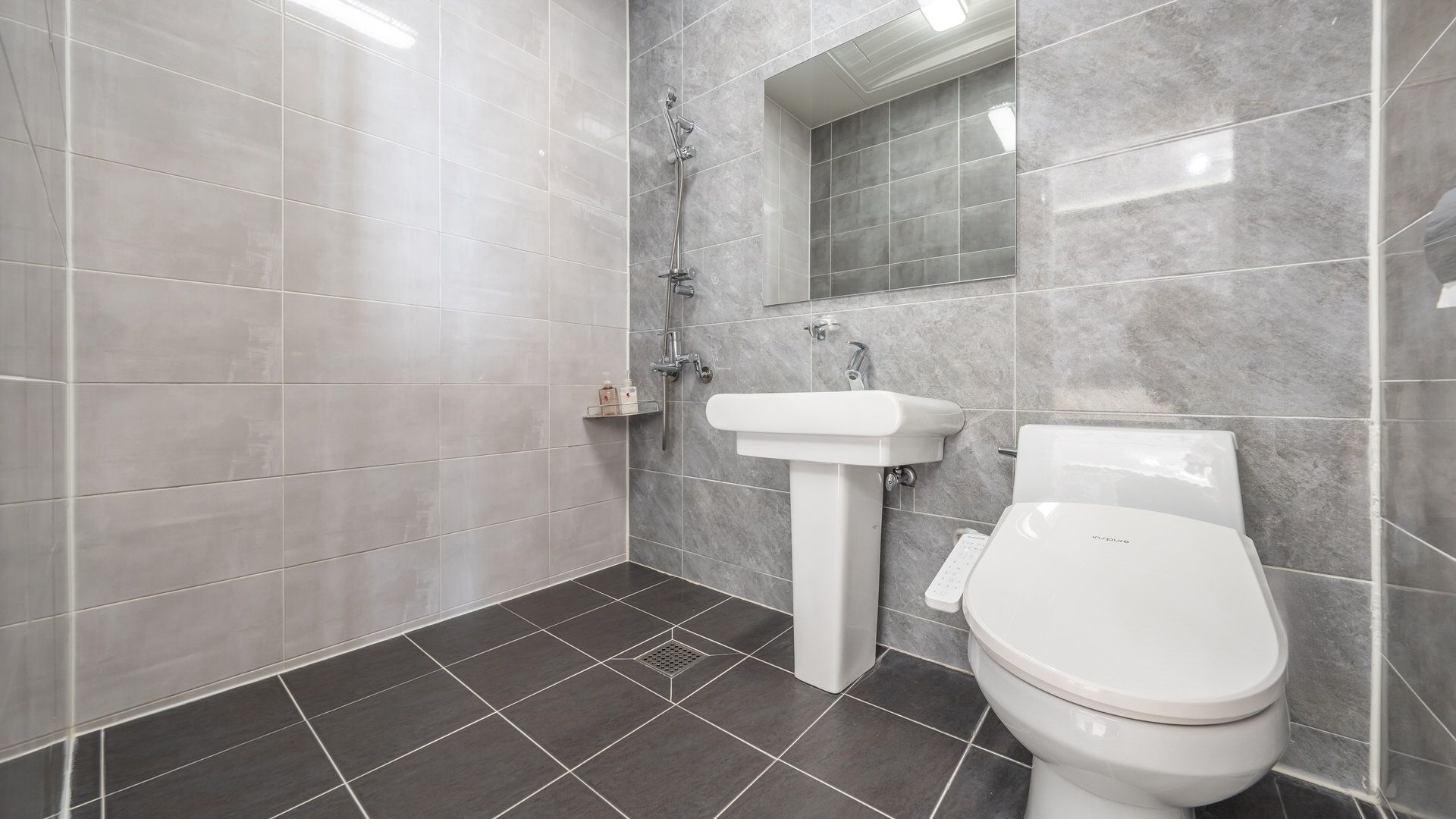 Un baño con inodoro, lavamanos y ducha.