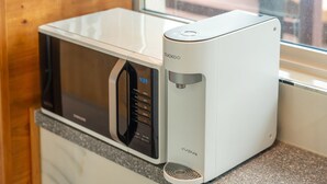 Eine moderne Küche mit Mikrowelle und Wasserspender.