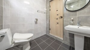 Ein modernes Badezimmer mit Toilette, Waschbecken und Duschbereich.