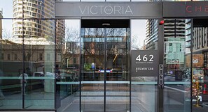 The entrance to Victoria, a hotel with a glass facade, located at 462 Elizabeth Street, developed by Golden Age. - Lumina Stays - Victoria One (Melbourne)