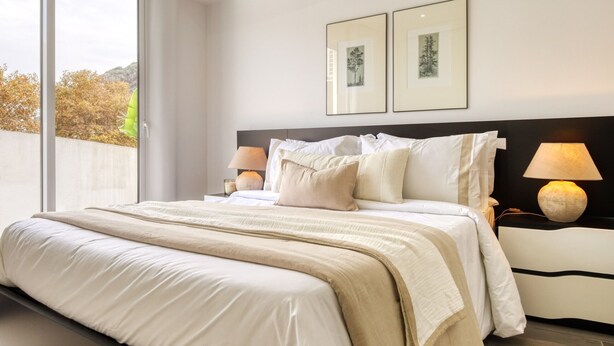 A modern hotel room with a large bed, two bedside lamps, and framed artwork on the wall. - Ribas Machico, a Home in Madeira (Machico)