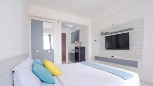 Ein Schlafzimmer mit Bett, Wandfernseher und Kleiderschrank.