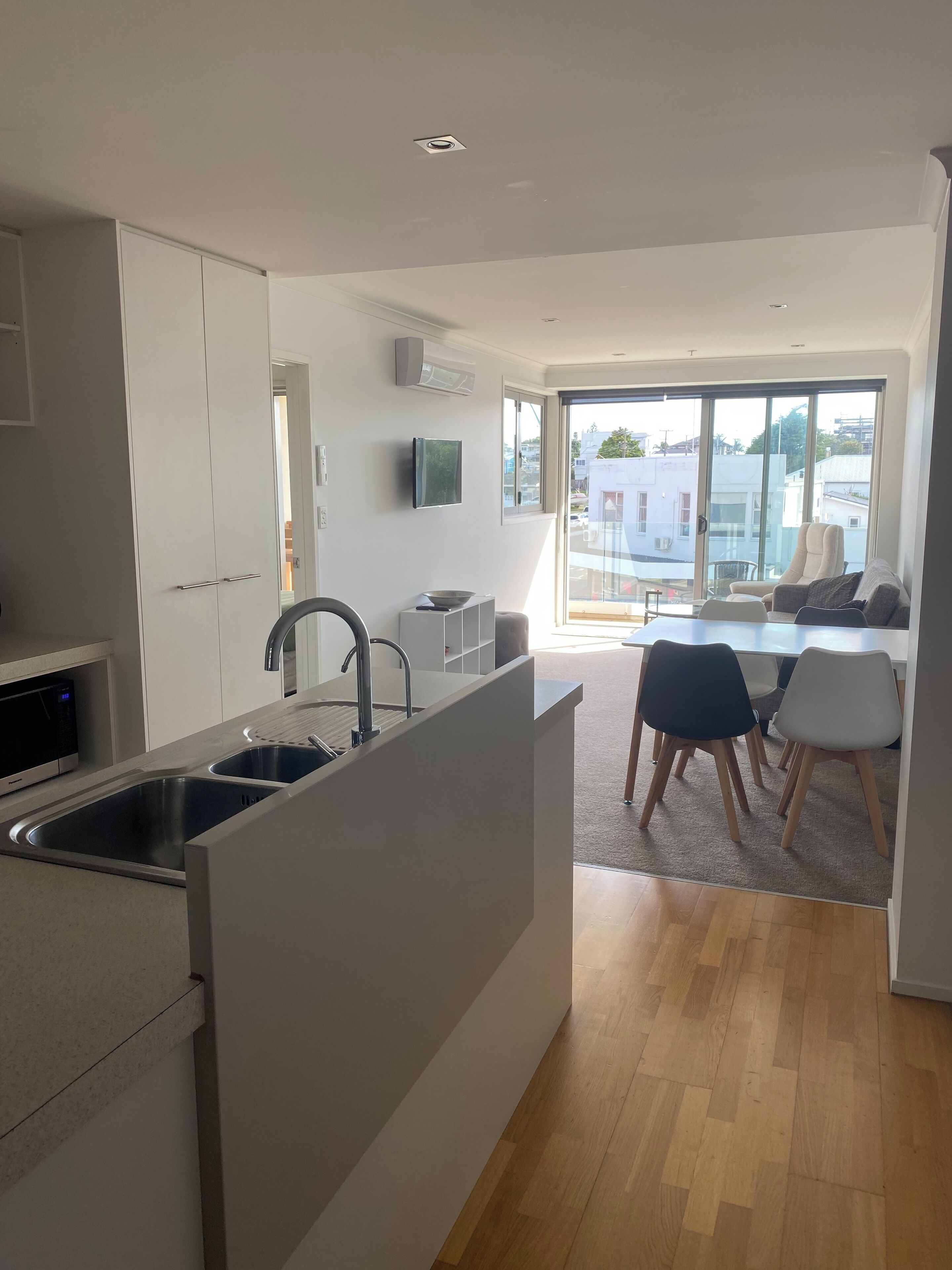 Uma cozinha moderna com ilha integrada, área de jantar com cadeiras e uma grande janela com vista para a cidade.
