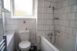 Ein kleines Badezimmer mit Toilette, Waschbecken und Badewanne.