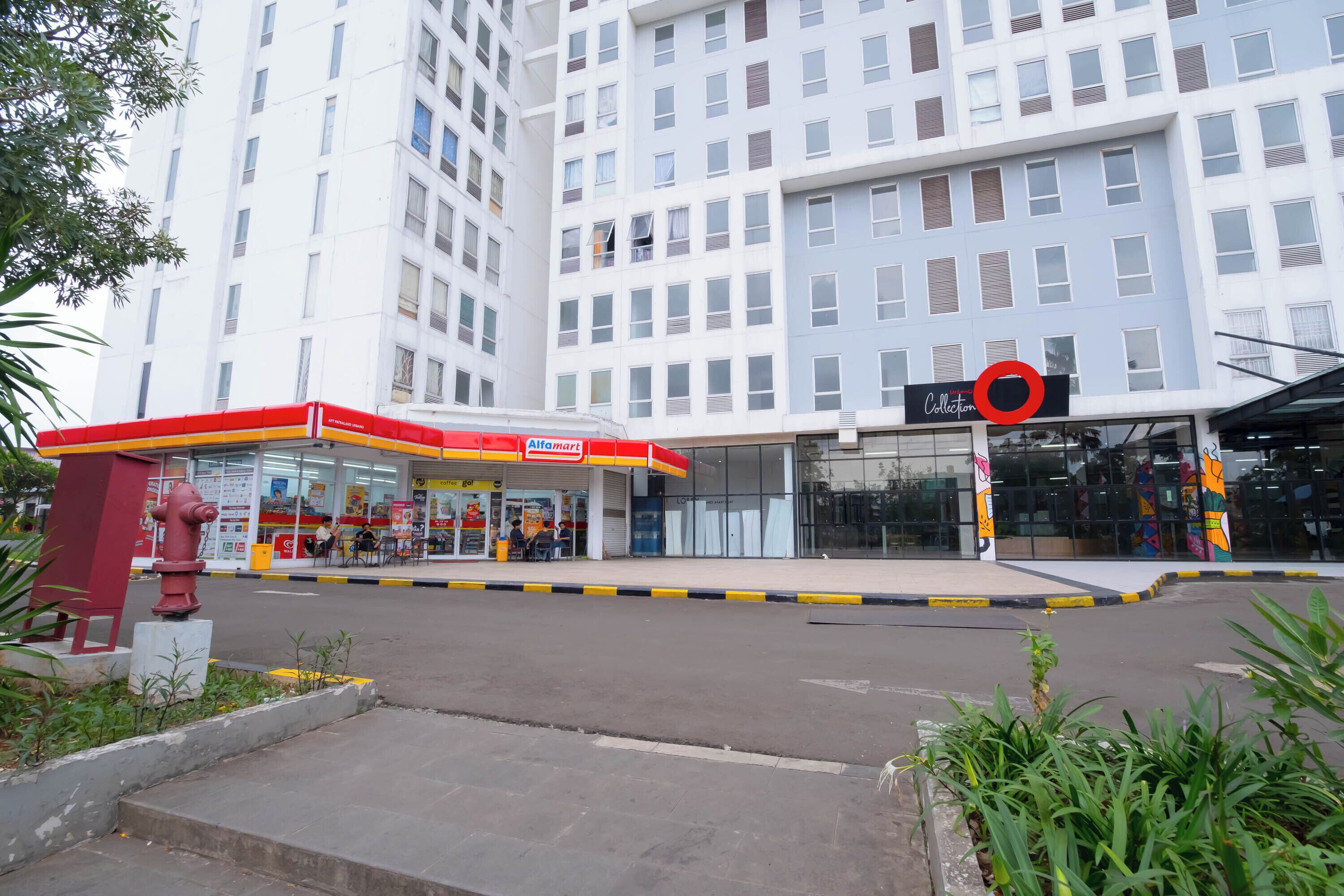 A modern building with a gas station and a shopping mall entrance.