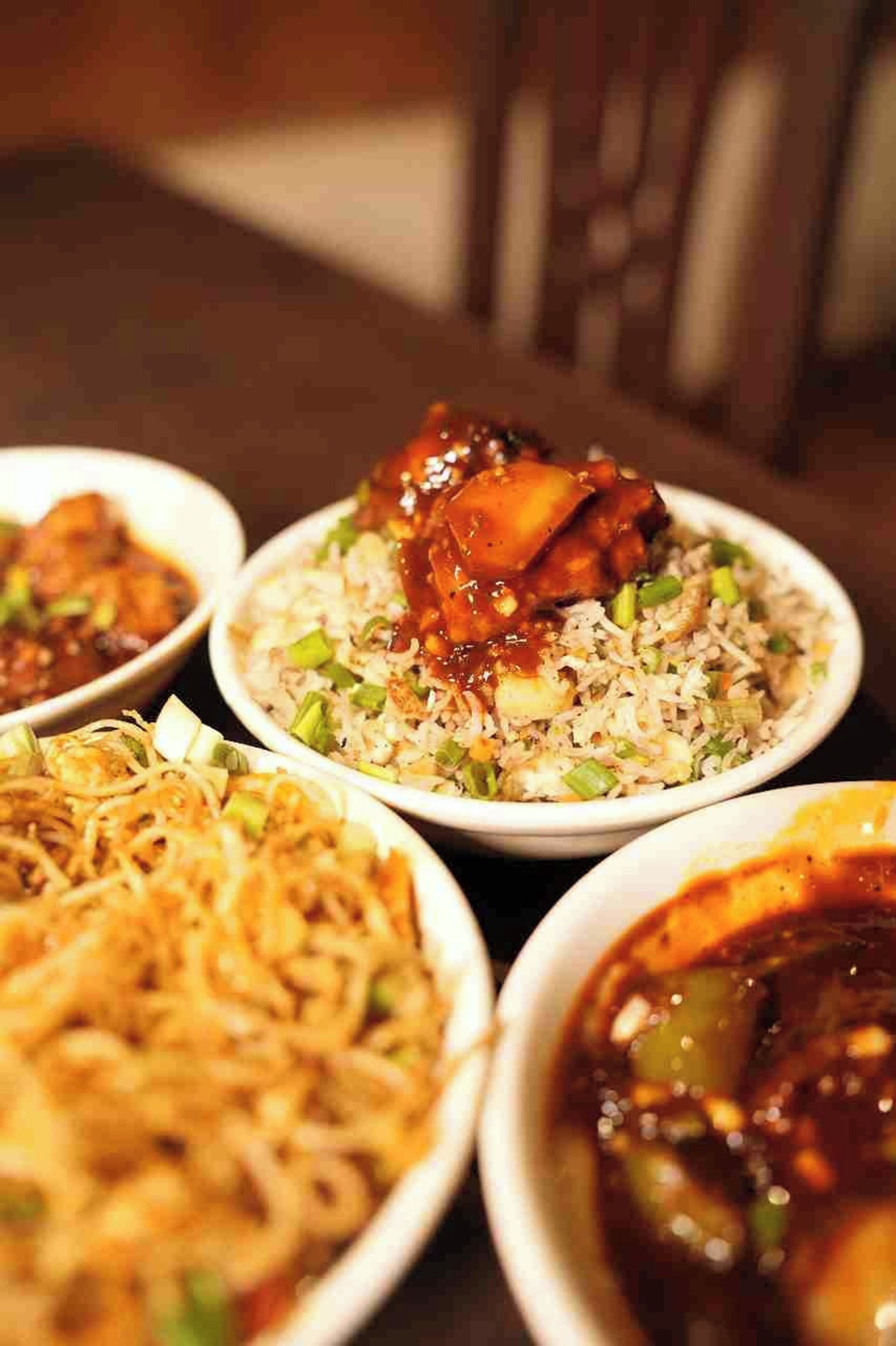 Une table où l’on trouve divers plats, notamment du riz frit, des nouilles et un bol de soupe.
