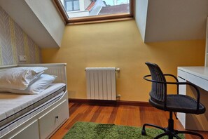 A bedroom with a bed, a radiator, a window, a desk, and a chair. - 1A137 Apartamento con encanto puerto deportivo (Gijón)