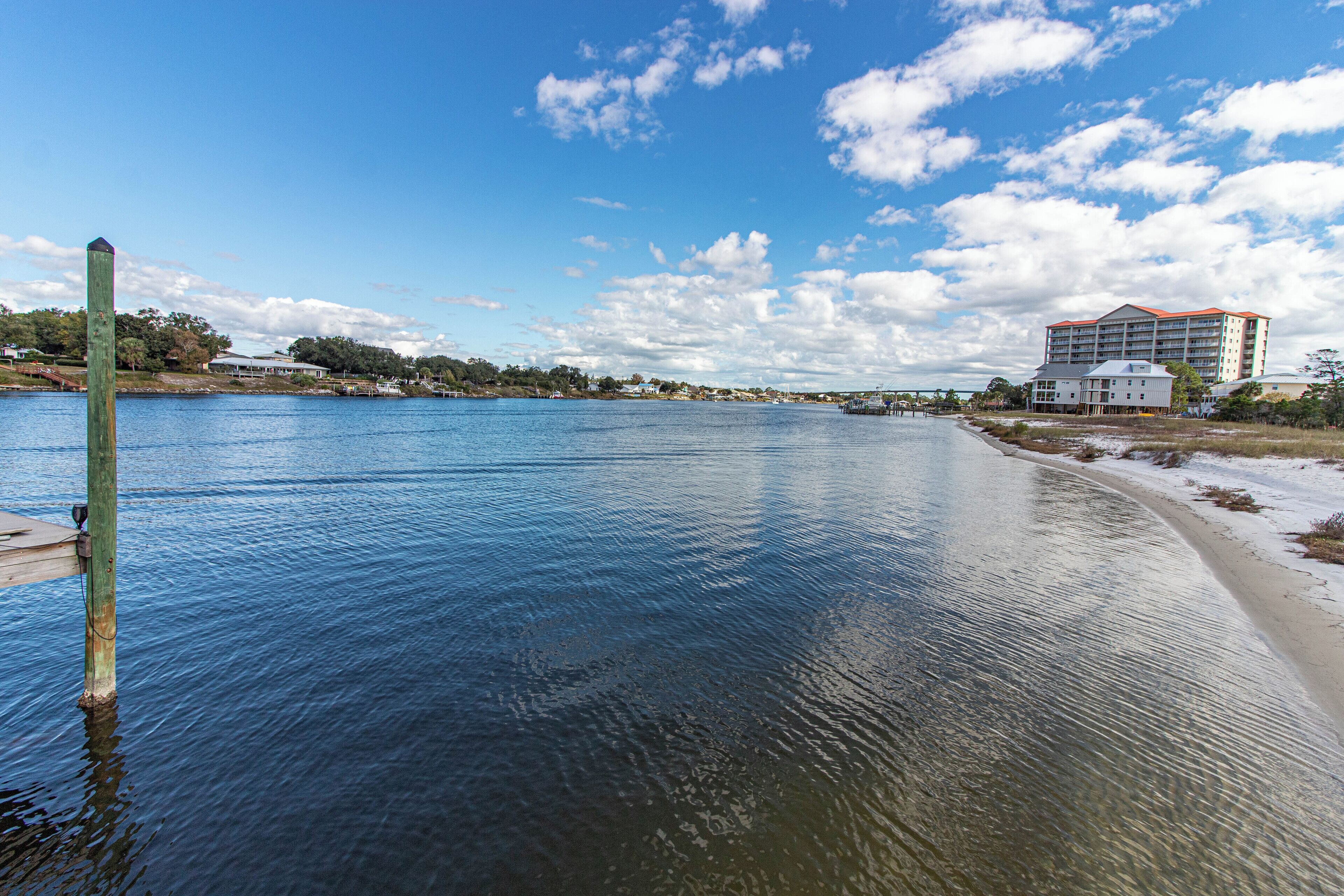 A waterfront hotel with a dock, a beach, and a view of the water.