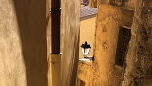 Una estrecha escalera de piedra en un edificio histórico con paredes amarillas y un farol.