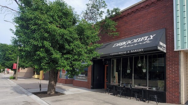 Een bakstenen gebouw met een winkel, genaamd 'Dragonfly Coffee House & Bakery'.