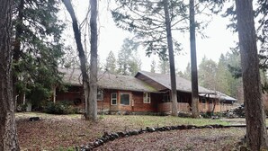 A rustic cabin surrounded by tall trees, with a stone pathway leading to the entrance. - Private Country Paradise with Beautiful Indoor Pool and Spa. PET FRIENDLY (Cave Junction)