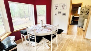 A dining area with a round table, white chairs, a clock on the wall, and large windows. - Private Country Paradise with Beautiful Indoor Pool and Spa. PET FRIENDLY (Cave Junction)
