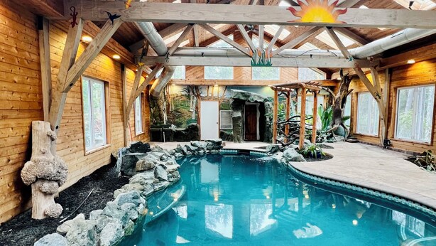 A wooden cabin with a pool, wooden beams, and a sun decoration on the ceiling. - Private Country Paradise with Beautiful Indoor Pool and Spa. PET FRIENDLY (Cave Junction)