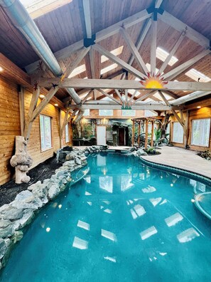 A wooden cabin with a pool, wooden beams, and a sun decoration on the ceiling.
