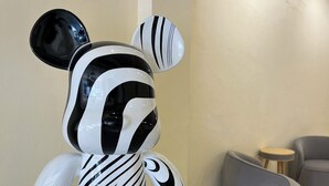 Una escultura con temática de cebra en un vestíbulo con mobiliario moderno y suelo de baldosas.