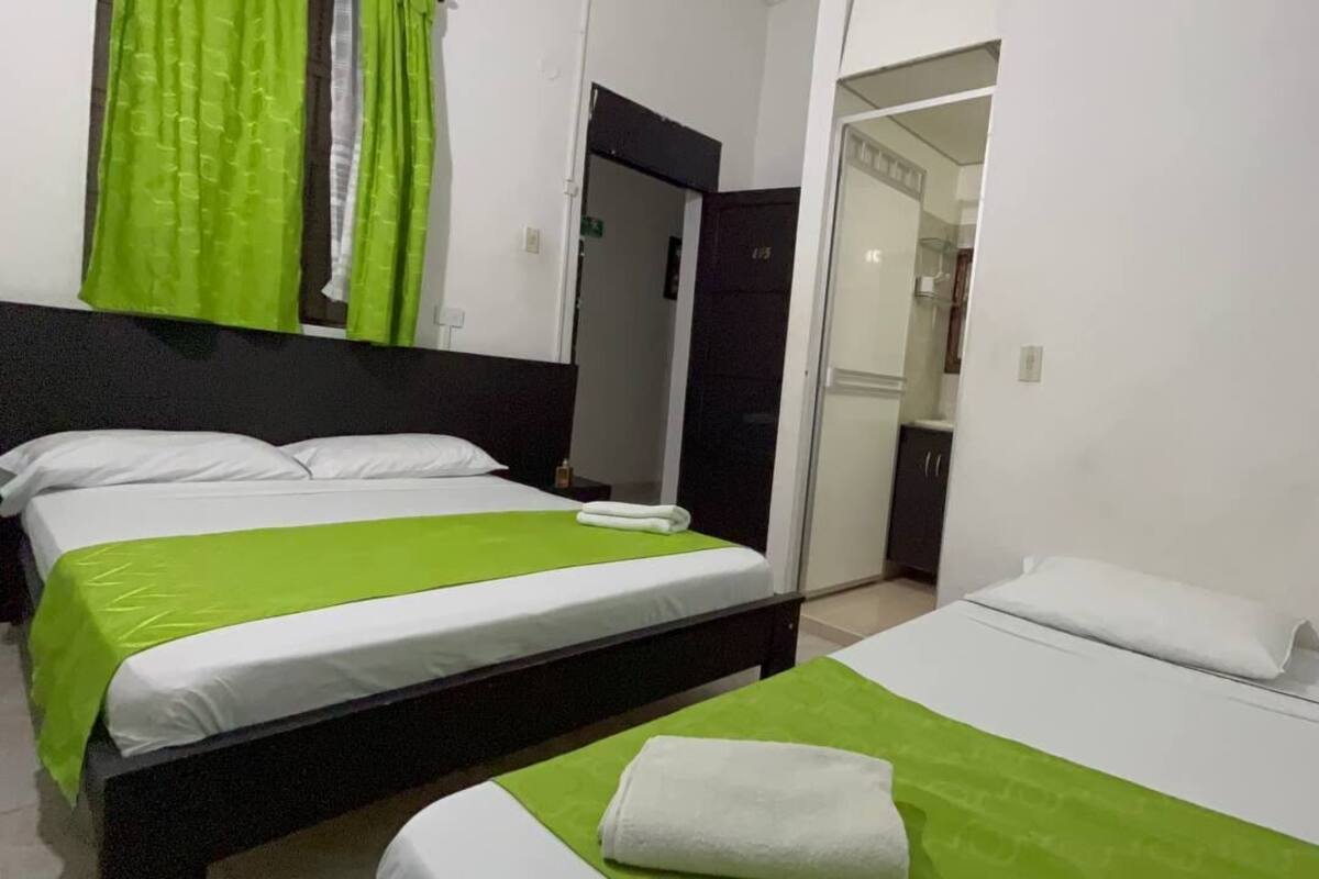 Une chambre d’hôtel avec deux lits, une salle de bain et une kitchenette.