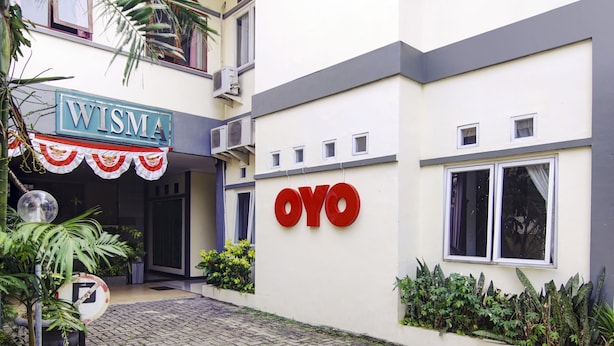 Ein Gebäude mit einem Schild, auf dem "WISMA" und einem weiteren Schild, auf dem "OYO" steht.