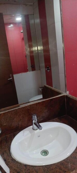 Bathroom features a sink and mirror above a striped wall.