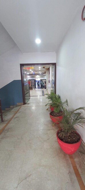 Stroll through the beautifully landscaped corridor, lined with potted plants, to the welcoming reception area.
