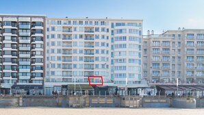 Ett hotell vid stranden med flera våningar, balkonger och en strandpromenad.