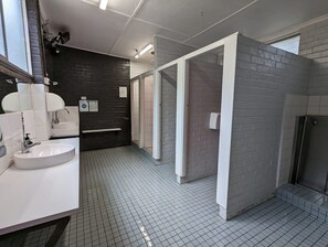 A modern bathroom with a white sink, a mirror, and a tiled floor. - Tiny Away Escape at Grampians Edge (Dadswells Bridge)