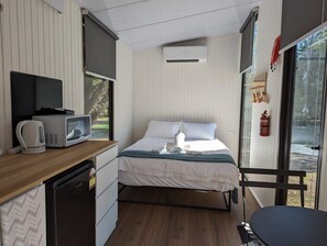A compact room with a bed, a small kitchenette, a microwave, a kettle, and a fire extinguisher. - Tiny Away Escape at Grampians Edge (Dadswells Bridge)