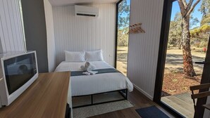 A modern bedroom with a bed, a television, and a view of the outdoors. - Tiny Away Escape at Grampians Edge (Dadswells Bridge)