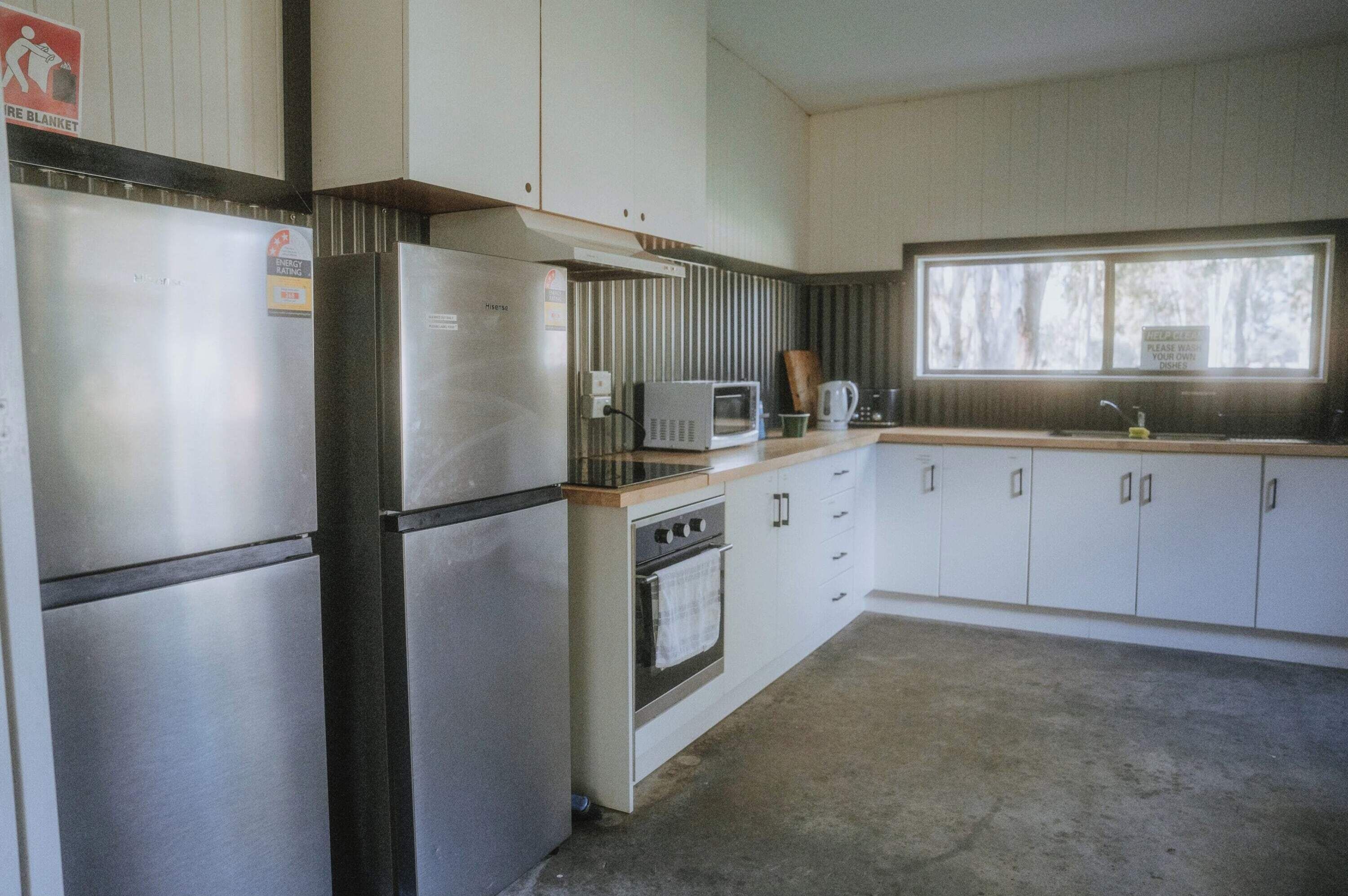 A compact kitchen with a refrigerator, microwave, stove, and sink.
