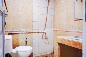 Un baño con inodoro, ducha y lavamanos.