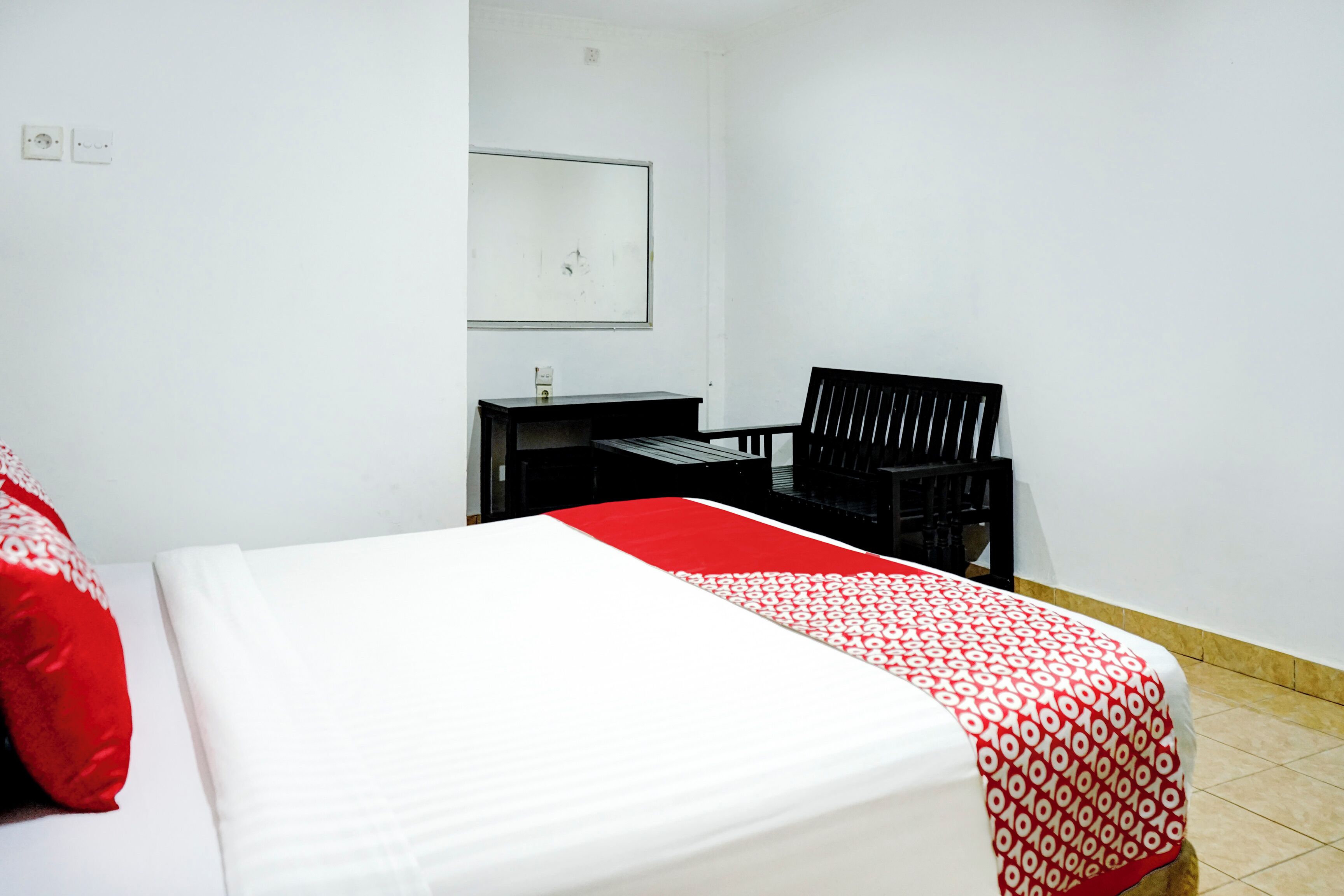 Una habitación de hotel con una cama, un escritorio y una silla.