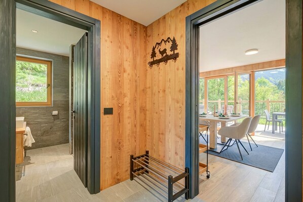 A wooden interior with a dining area, a rack, and a view of the outdoors. - Edelweiss (Livigno)