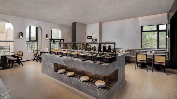 Ein moderner Essbereich mit Buffet, Sitzgelegenheiten und großen Fenstern für viel Tageslicht.