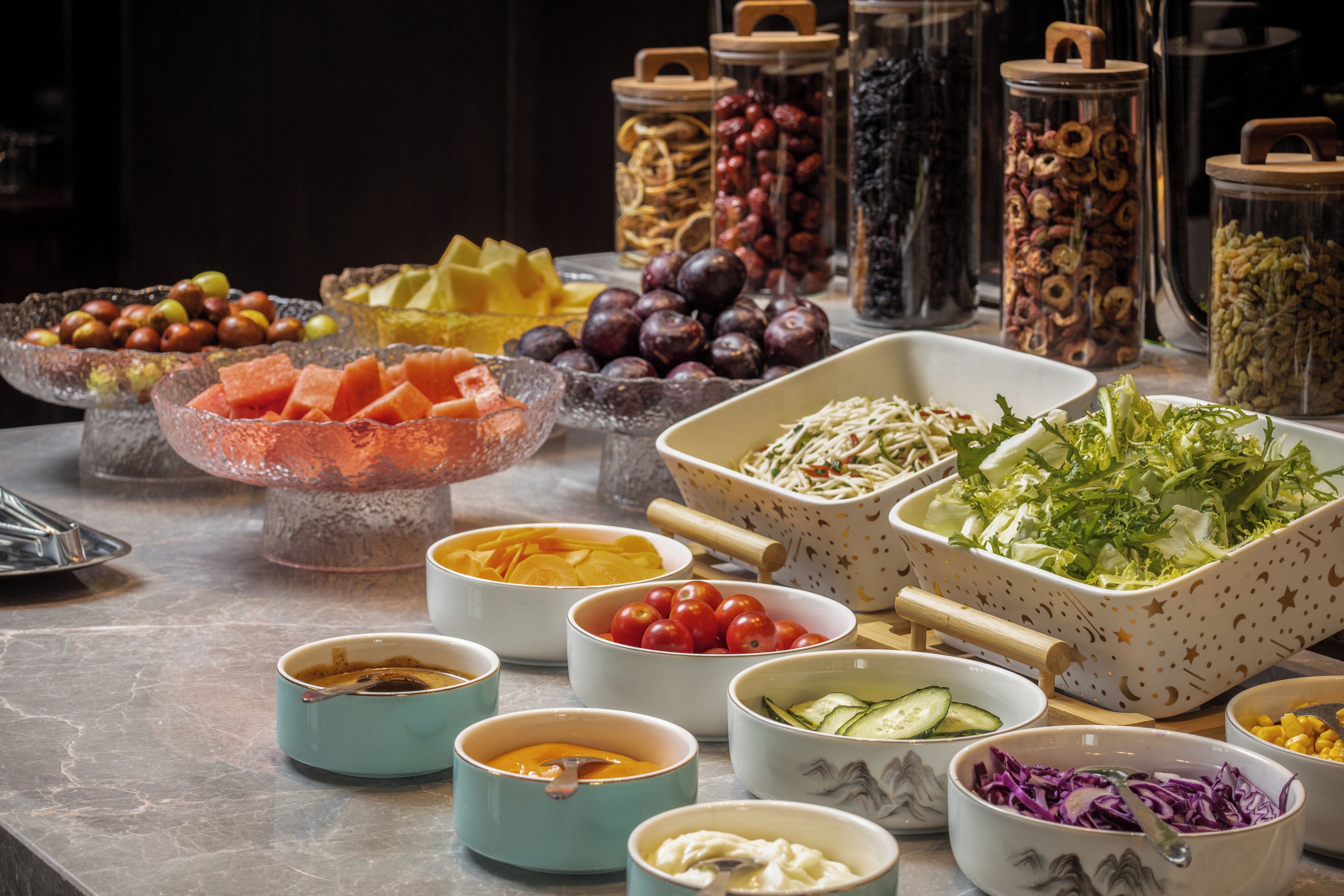 A buffet table with various food items and condiments.