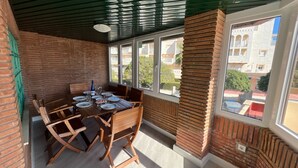 A dining area with a brick wall, wooden table, and chairs. - Las Pergolas by Interhome (Jávea)