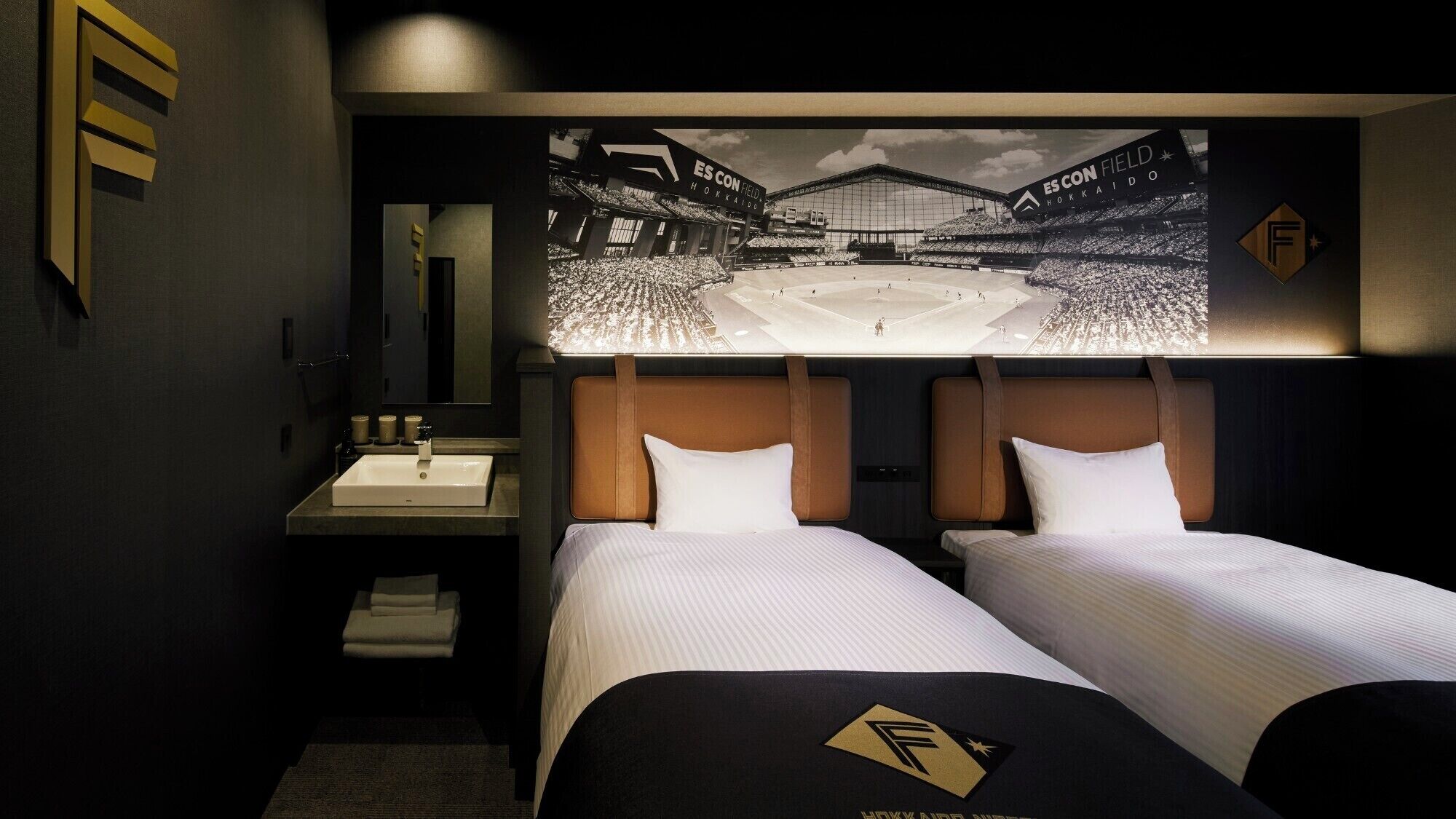 Una habitación de hotel con dos camas, un lavamanos y un espejo.