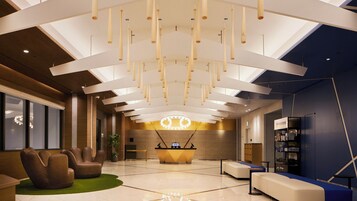 Um lobby moderno com uma receção, áreas de estar e um grande candelabro.