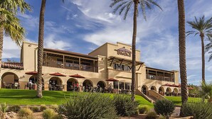 A hotel with a patio area, outdoor seating, and palm trees. - Upgraded Golfer's Oasis! Heated Pool, BBQ, Gate Guarded & Pet Friendly! (Phoenix)