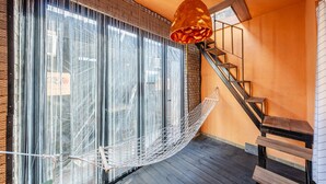 A wooden staircase with a metal railing, a hammock hanging by a window, and a hanging light fixture. - Gangchon Afternoon Pool Villa Pension (Chuncheon)