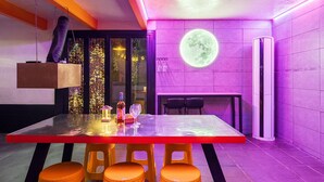 A modern dining area with a large table, chairs, and a hanging light fixture. - Gangchon Afternoon Pool Villa Pension (Chuncheon)