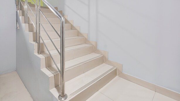 A staircase with a metal handrail and beige steps. - Hotel O Panakukkang Near Mall Panakkukang Formerly Hawai Inn (Makassar)