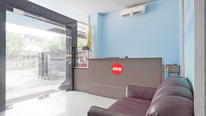 A reception area with a sofa, a reception desk, and a view of the outside. - Hotel O Panakukkang Near Mall Panakkukang Formerly Hawai Inn (Makassar)