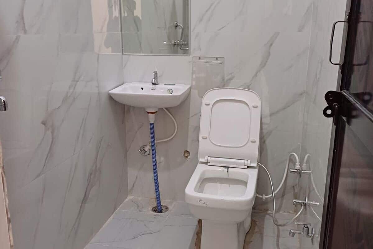 A bathroom with a toilet, sink, and shower.