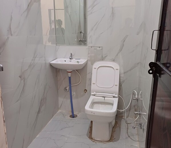 A bathroom with a toilet, sink, and shower. - Saavra Hotels & Resorts (Jaipur)