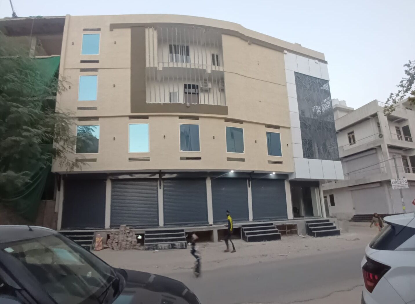 Un edificio de varios pisos con fachada plana, grandes ventanales y un letrero que indica una escuela de niñas.